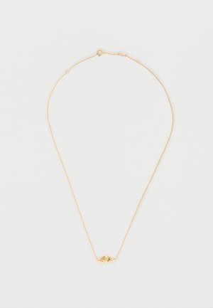 Herkkä kullanvärinen ketjukaulakoru, jossa on pieni solmu ja kirkas yksittäinen jalokiviriipus valkoisella taustalla.