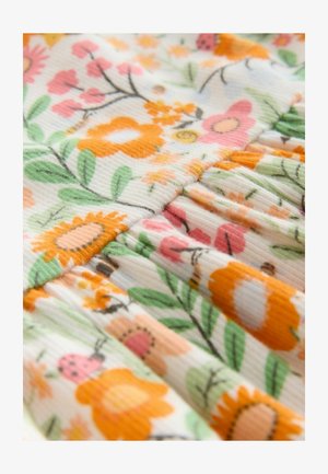 Květinová bavlněná tkanina se vzory v oranžové, růžové a zelené barvě, s plisovanou strukturou a žebrovanými detaily, zvýrazňující slunečnice a broučky.