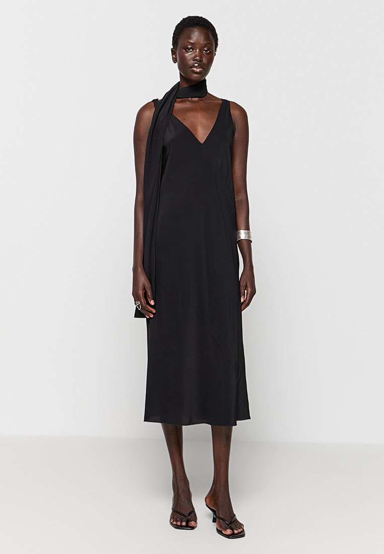 Czarna, bezrękawnikowa sukienka midi z dekoltem w serek, z drapowanym detalem w postaci szalika i gładką teksturą. Tkanina ma subtelny połysk.