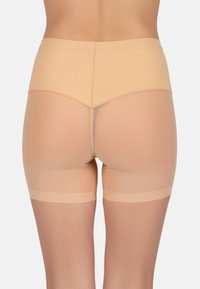 Beige rövidnadrág átlátszó panel dizájnnal, sima textúrával és közép-Térd vágással. A derékpánt varrás nélküli a kényelem érdekében.