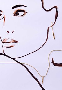 Gouden ketting met een rechthoekige hanger met textuur, vergezeld van een bijpassende gouden oorbel. De achtergrond toont een minimalistische lijntekening van een gezicht.