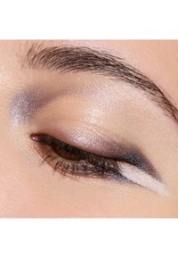 Close-up af et øje med øjenskygge i nuancer af grå og sølv, glat tekstur, subtil glans og en defineret vingeformet eyeliner-detalje.