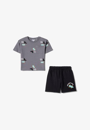 Camiseta gris de manga corta con estampado de monopatines y texto "Keep Going", combinada con pantalones cortos negros que presentan un monopatín y el texto "Project Ride".