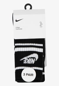 Sorte crew-sokker i en 3-pak med hvide striber og Nike-logoet. Polstret materiale for komfort. Emballagen indeholder et rundt mærkat med teksten "3 PAR."