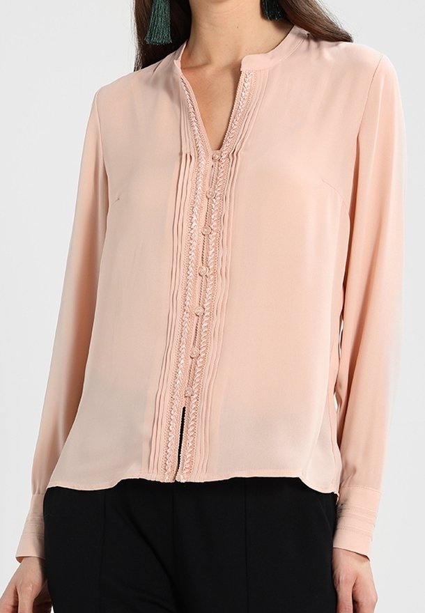 Blush pink blouse made of lightweight fabric, featuring a high neckline, front button details, and vertical pleats along the placket.