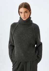 Grijs, chunky gebreid sweater met een hoge col, raglan mouwen en een geribbelde zoom. Wolmix met een zachte, gestructureerde afwerking.