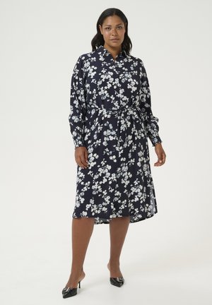 Navy blue floral midi dress with long sleeves, belted waist, and button closure. Features white floral patterns and smooth fabric texture.