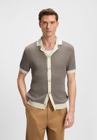 Cardigan a maniche corte in maglia marrone scuro e beige, con scollo con colletto, davanti con bottoni e orlo e polsini a coste.