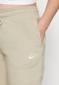 Nike Sportswear Calças de fato de treino - rattan/white