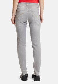 Grå denimjeans med smal passform, med en medelhög midja, bakfickor med dekorativ söm och en lätt blekt struktur.