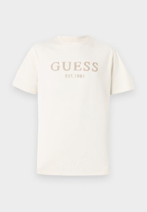 White short-sleeved t-shirt made of soft cotton, featuring embossed "GUESS" and "EST. 1981" in light beige on the front.