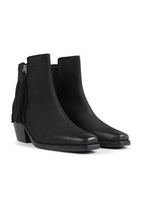 Botines de cuero negro hasta el tobillo con punta afilada, cremallera lateral y detalle de flecos en el exterior. Tacón grueso con suela texturada.
