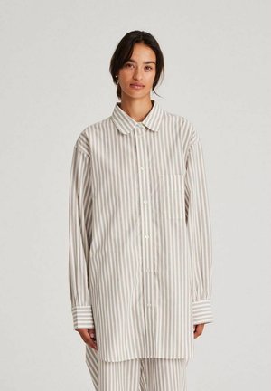 Lightweight long-sleeve shirt in cream with taupe stripes. Features a button-up front, collar, and a single chest pocket. Soft cotton fabric.
