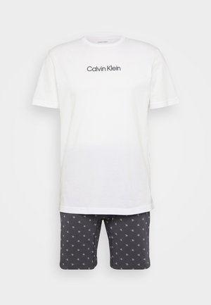 Wit katoenen T-shirt met het logo "Calvin Klein", gecombineerd met donkergrijze shorts met een klein wit grafisch patroon. Korte mouwen en ronde hals.