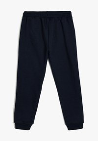 Marine pyjama's gemaakt van zachte stof met een elastische tailleband, taps toelopende manchetten en een relaxte pasvorm. Geen zichtbare zakken of patronen.