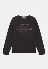 Sudadera negra con un logo "CALVIN KLEIN JEANS" dorado y texturizado. Cuello redondo clásico, mangas largas y puños y dobladillo acanalados.