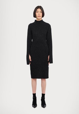 Rochie neagră, cu model canelat, din tricot, cu mâneci lungi și guler înalt. Design aderent cu un hem de lungime până la genunchi și țesătură texturată.