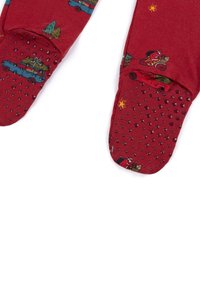 Pantalones de pijama rojos de algodón suave con estampados navideños de coches y árboles, con un patrón de agarre texturizado y punteado en las suelas.