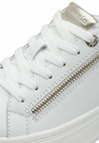 Sneaker in pelle bianca con lacci bianchi piatti, una cerniera argentata laterale e un'etichetta metallica con il nome del marchio.