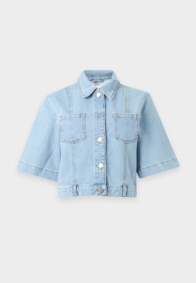 Veste en jean bleu clair coupée courte avec manches courtes, boutons sur le devant, deux poches poitrine et col classique.