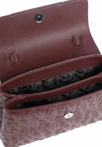 Borsa a tracolla in pelle testurizzata color bordeaux con chiusura a scatto superiore, due scomparti e logo impresso sul retro. Fodera interna nera.