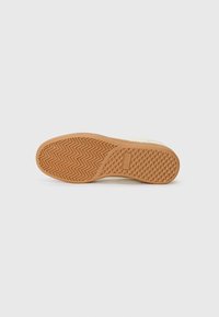 Shoe sole with a textured, herringbone pattern. Color: light brown rubber. Smooth edges and slight curvature at the toe area.