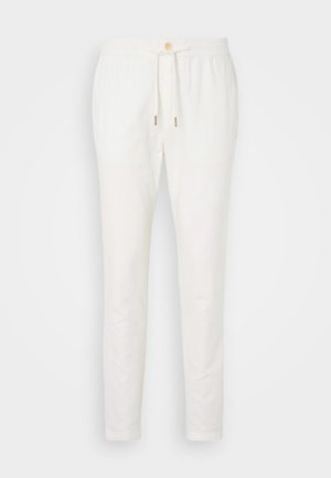Pantalons en lin blanc avec une taille à cordon, fermeture à bouton et coupe fuselée. Texture lisse avec un minimum de détails et sans motifs visibles.