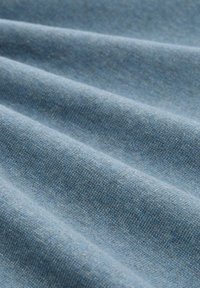 Hellblauer Stoff mit einer sanften Textur, der subtile Webmuster und sanfte Falten zeigt, was auf ein mittleres Gewicht und ein glattes Finish hindeutet.