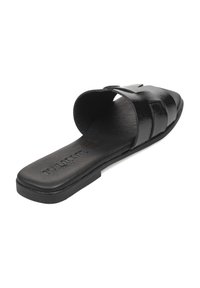 Sandalia negra de plataforma con parte superior de cuero brillante, diseño de punta abierta y suela plana. Presenta tres tiras horizontales a través del empeine.