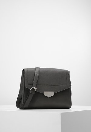 Sort læder crossbody taske med justerbar strop og sølvfarvet metalspænde på frontklappen, vist på hvid piedestal.