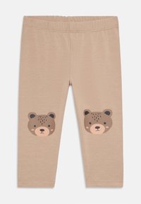 Beige leggings van zachte stof, met daarop twee berenhoofden gedrukt op de knieën. Elastische tailleband voor extra comfort, gladde textuur.