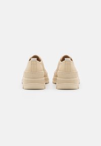 Beez sneakerid tekstuuri viimistlusega, millel on pehme tallaga, ümar varvas ja väike tagumine tõmme. Puhas ja minimalistlik disain.