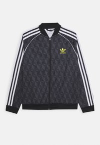 Chaqueta bomber negra con diseño estampado, cierre de cremallera, acentos de tres rayas blancas en las mangas y un logo verde de Adidas en el pecho.