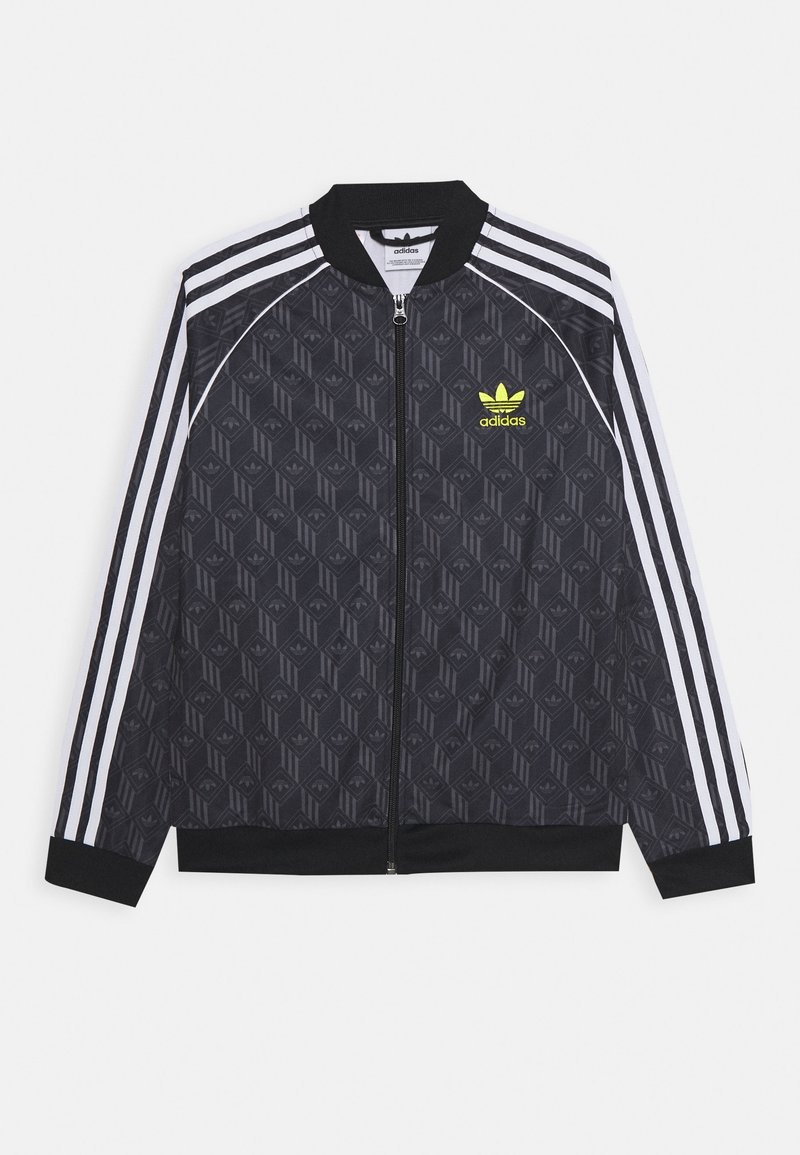 Chaqueta bomber negra con diseño estampado, cierre de cremallera, acentos de tres rayas blancas en las mangas y un logo verde de Adidas en el pecho.