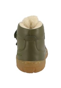 Stivale in pelle verde oliva con forma rotonda, bordo in morbido pile beige, e suola in gomma marrone. Dettagli di cucitura laterale visibili.