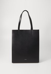 Sac à main en cuir noir avec deux poignées supérieures, forme rectangulaire plate, design minimaliste et marquage près du bas.