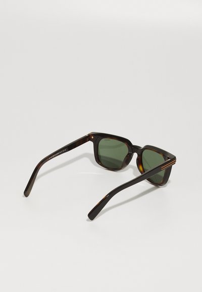 Tortoiseshell sunglasses with green lenses, square frame design, and slender arms featuring subtle metallic accents.