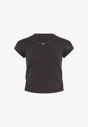Czarny krótki krótki t-shirt z marszczeniem po bokach i srebrnym naszyjnikiem z pojedynczym szarym perłowym zawieszkiem.