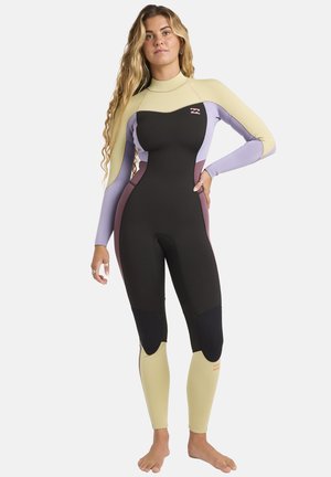 Combinaison de plongée présentant un mélange de panneaux noirs, jaunes, violets et bordeaux, fabriquée en matière extensible avec des genouillères renforcées et un col haut.