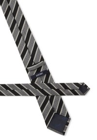 Une cravate rayée noire et argentée présentant un motif texturé, un tissu lisse et une étiquette de logo. La cravate a un design diagonal classique.