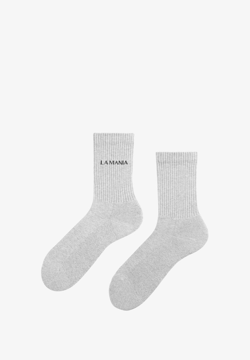 Szürke bordázott zoknik, fekete "LA MANIA" felirattal, puhán textilekészítve, sima felülettel. Bokáig érő dizájn.