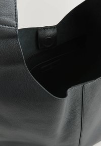 Borsa a tracolla nera in pelle con texture liscia, apertura superiore e una sottile tasca interna. Presenta un design minimalista e linee pulite.