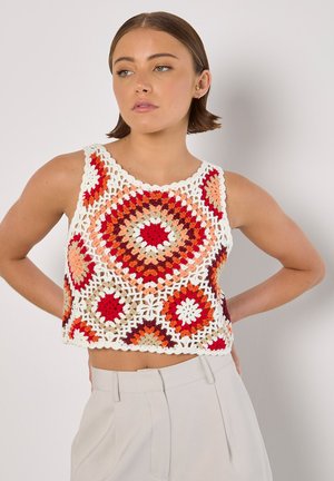 Débardeur au crochet avec des motifs hexagonaux colorés en fil rouge, orange et blanc, doté d'un col festonné et d'un design à mailles ouvertes.