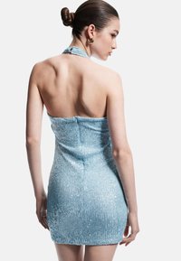 Mini vestido azul brillante hecho de tela acanalada y con lentejuelas. Presenta un cuello halter y una silueta ajustada con cierre en la parte posterior.