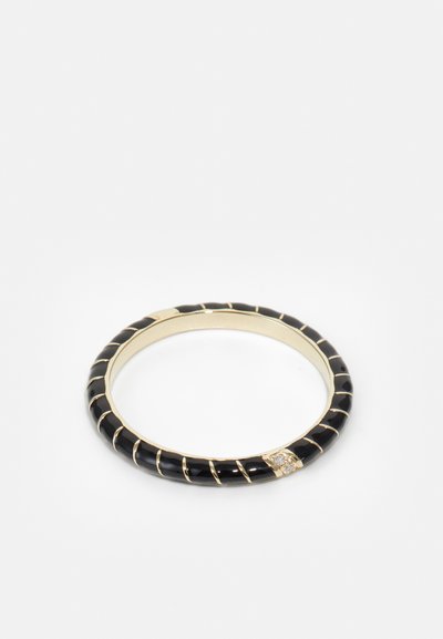 Zwarte bangle armband met gouden accenten, voorzien van een gestreepte textuur en een kleine heldere edelsteen die in het ontwerp is verwerkt.