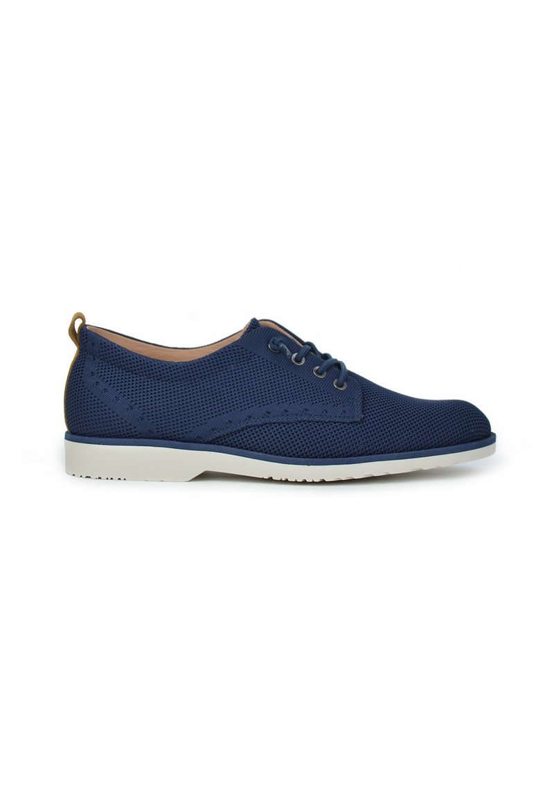 Zapatillas de malla azul marino con suela de goma blanca, que cuentan con un diseño de cordones, textura perforada y detalles marrones en el talón.