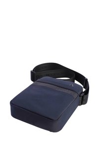 Bolso cruzado compacto de color azul marino con correa negra ajustable y bolsillo frontal con cremallera, diseñado para el uso diario.