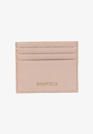 Porta carte in pelle beige testurizzata con tre fessure per carte e il nome del marchio "COCCINELLE" impresso in oro sul davanti.