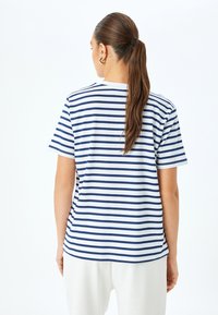 Marineblauwe en witte gestreepte katoenen t-shirt met korte mouwen, ronde halslijn en een ontspannen pasvorm, met een gebogen zoomontwerp.