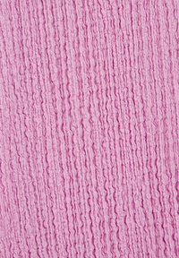 Teksturna roza tkanina s gubanim dizajnom, ki vsebuje vertikalne valove in mehak videz, primerna za oblazinjeno pohištvo ali obrt.